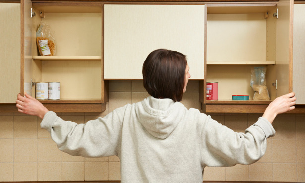 Someone opening empty kitchen cupboards