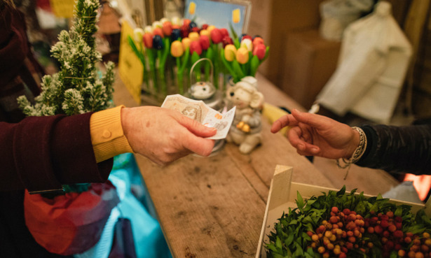 hands exchanging cash in flower shop