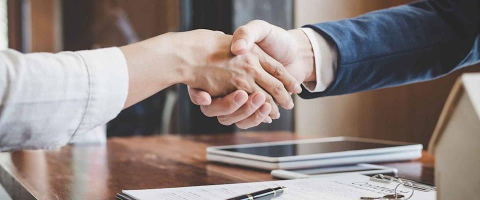 Real estate agent and customers shaking hands together celebrating finished contract after about home insurance and investment loan, handshake and successful deal.