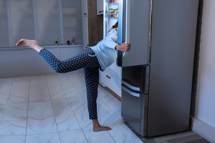 Woman Looking For Food In Open Refrigerator