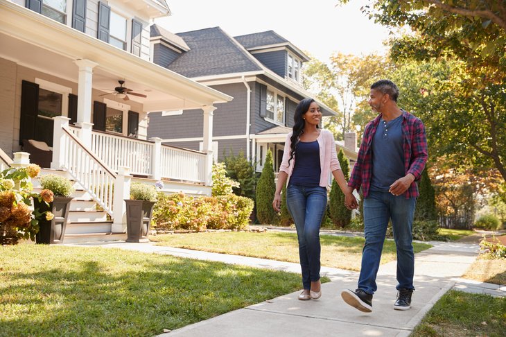 Millennial couple walking through their new neighborhood as homeowners