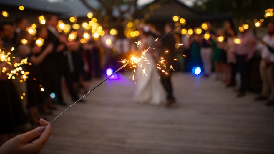 Wedding guests hold sparklers