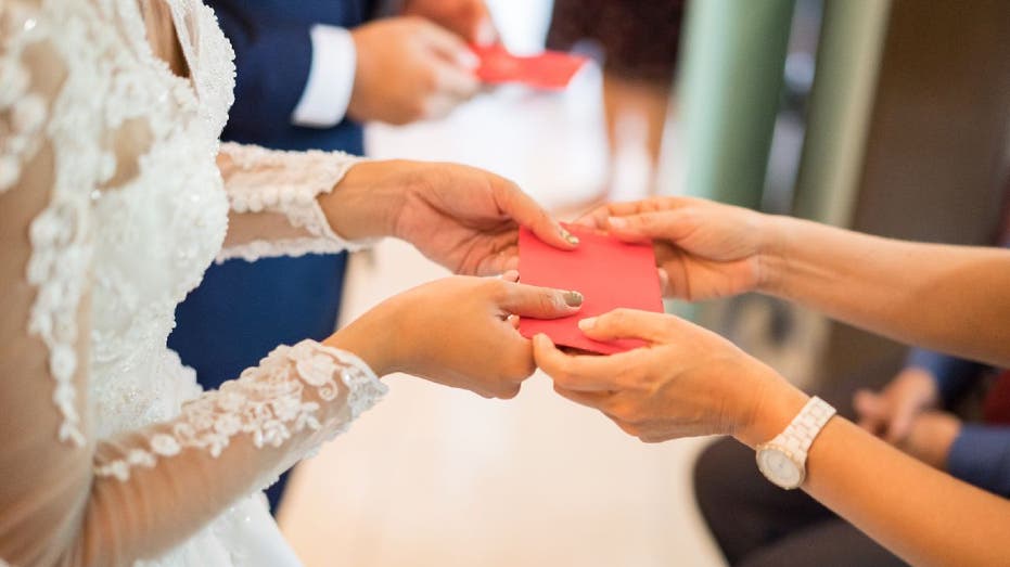Bride and groom receive red gift envelopes